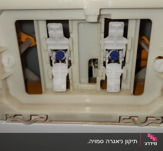 מנגנון פנימי של ניאגרה סמויה בקיר לפני הרכבת לחצן הפעלה